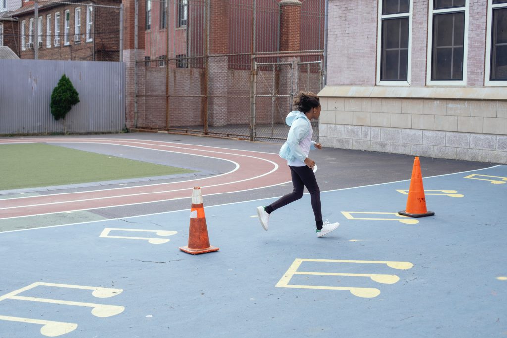 girl running around playground markings